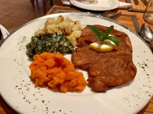 un piatto di cibo con pollo e verdure su un tavolo di Schuetzenhaus Guesthouse a Keetmanshoop