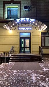 a front door of a building with stairs and lights at Rooms Hotel Semey in Semey