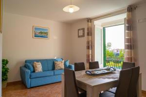 a living room with a table and a blue couch at Lidia's House in Minori