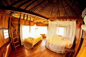 a large room with two beds in a cabin at Les Collines De Niassam in Palmarin