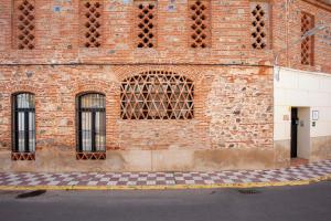 un edificio de ladrillo con ventanas laterales en Lobelia Suites- Alojamientos petfriendly en La Garrovilla