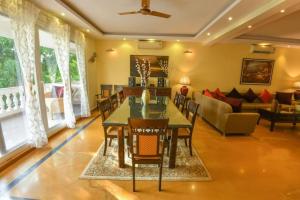 a dining room with a table and chairs and a couch at Villa Nazuri w Caretaker in Candolim