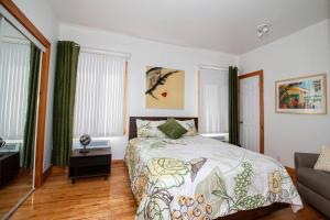 - une chambre avec un lit, un canapé et des fenêtres dans l'établissement Villa Calypso avec vue sur la baie de Ste-Luce, à Sainte-Luce-sur-Mer