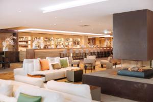 a lobby with white couches and a fireplace at Valtur Cervinia Cristallo Ski Resort in Breuil-Cervinia