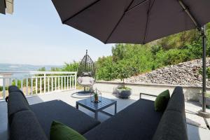 un soggiorno con divano e ombrellone di Apartment Adrian2 a Trogir