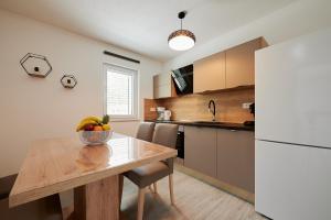 a kitchen with a table with a bowl of fruit on it at Apartment Adrian2 in Trogir