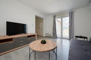 uma sala de estar com uma televisão e uma mesa em Apartment Adrian2 em Trogir