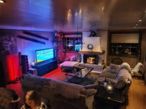 ein Wohnzimmer mit Sofas, einem TV und einem Kamin in der Unterkunft Ski In - Ski Out, Jacuzzi, Panorama View in Geilo