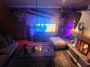 uma sala de estar com um sofá e uma televisão em Ski In - Ski Out, Jacuzzi, Panorama View em Geilo
