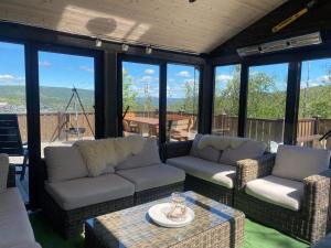 a screened in porch with couches and a table at Ski In - Ski Out, Jacuzzi, Panorama View in Geilo