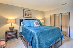 a bedroom with a bed with a blue comforter at Lubbock Townhome with Grill Near TTU and Downtown! in Lubbock