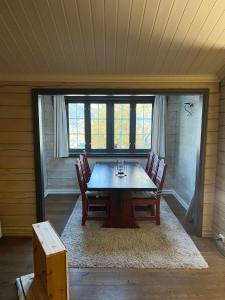 ein Esszimmer mit einem Holztisch und Stühlen in der Unterkunft Ski In - Ski Out, Jacuzzi, Panorama View in Geilo