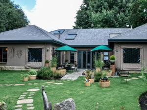 ein Haus mit einem Hof mit Stühlen und Sonnenschirmen in der Unterkunft Stay!inClarens in Clarens