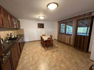 a kitchen with a table and a dining room at Vila Irina in Podu Coşnii
