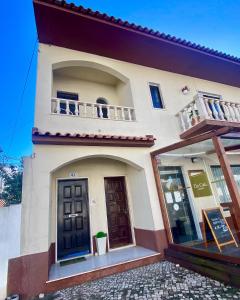 a white house with a balcony and a door at Spray B&B Sitio in Nazare, European style in Nazaré