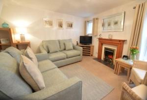 a living room with a couch and a fireplace at Cliff Cottage in Gorran Haven