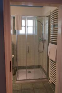 a shower with a glass door in a bathroom at Hotel Schäferhof in Schneverdingen