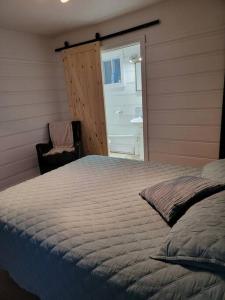 a bedroom with a bed and a chair and a bathroom at Corail de mer app 3 à juste 2 min de la plage in Sainte-Luce-sur-Mer