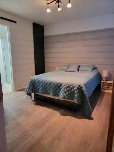 a bedroom with a bed and a wooden floor at Corail de mer app 3 à juste 2 min de la plage in Sainte-Luce-sur-Mer