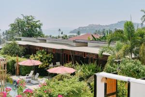 un complexe avec des tables et des parasols devant dans l'établissement The Loft Panwa Resort, à Panwa Beach