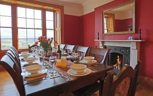 a dining room with a table and a fireplace at Follions Farmhouse in Morpeth