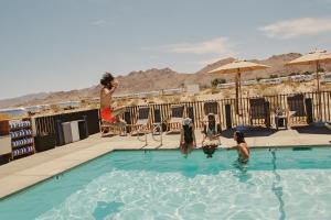 a group of people playing in a swimming pool at AutoCamp Joshua Tree in Joshua Tree