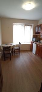 cocina con mesa, 2 sillas y ventana en Апартамент Александр 1, en Burgas