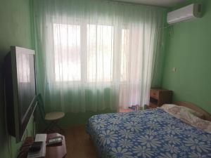 1 dormitorio con 1 cama y una ventana con cortinas en Апартамент Александр 1, en Burgas