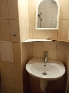 a bathroom with a white sink and a mirror at Апартамент Александр 1 in Burgas City