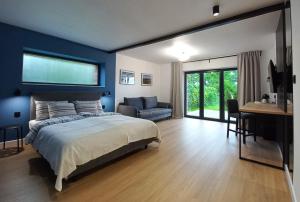 - une chambre avec des murs bleus, un lit et un bureau dans l'établissement Apartamenty Między Mostami, à Stegna