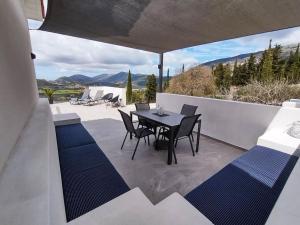 a patio with a table and chairs on a balcony at Villa Katerina Kefalonia in Kefallonia