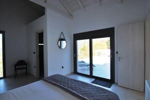 una camera da letto con un letto grande e una grande finestra di Villa Katerina Kefalonia a Cefalonia Altre 35 foto