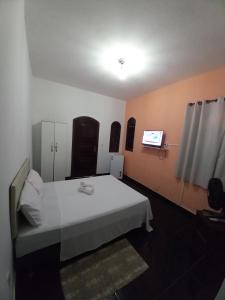 um quarto de hospital com uma cama e uma televisão em Suíte Pegadas na Areia em Arraial do Cabo