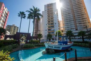a boat in a pool in a city with tall buildings at Casa Guilhermina com Piscina e Churrasqueira in Praia Grande