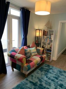 a living room with a couch and a window at Ground Floor Apartment in Exmouth