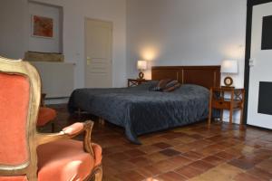 - une chambre avec un lit et une chaise dans l'établissement Chambres d'hôtes - Dîners - Piscine - centre-ville Bergerac 5km - Domaine de Bellevue Cottage, à Lembras