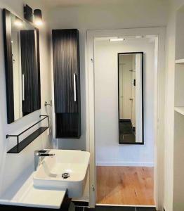 a bathroom with a white sink and a mirror at Mitten in Nastätten und doch im Grünen: schönes und modernes Apartment in Nastätten