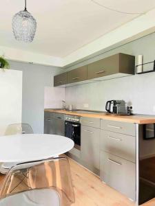 a kitchen with a white table and a white counter top at Mitten in Nastätten und doch im Grünen: schönes und modernes Apartment in Nastätten