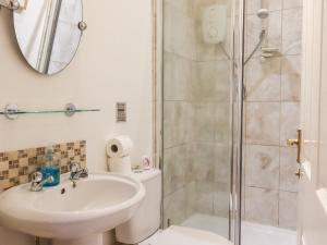 a bathroom with a toilet and a sink and a shower at Lair Close Cottage in Birstwith