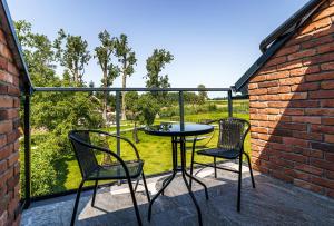d'une terrasse avec 2 chaises et une table sur un balcon. dans l'établissement Apartamenty Między Mostami, à Stegna