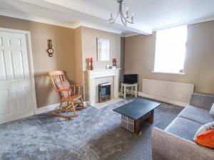 a living room with a couch and a fireplace at Greenmantle in Skinburness