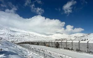 a snow covered mountain with a fence and a train at Deja Vu suite . Feel like Home in Majdal Shams