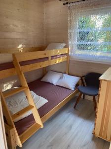 a bunk bed in a cabin with a desk and a chair at Dolina Wisełka in Wisełka