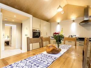 a kitchen with a table with a vase of flowers on it at Lodge 9 in Wareham