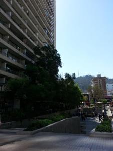 una acera frente a un edificio alto en Kuizi departamento Manuel Montt, en Santiago