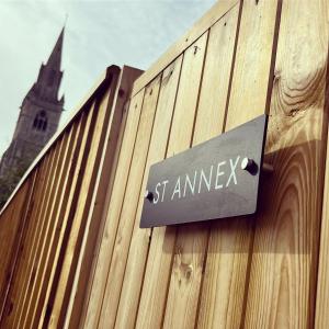 a sign on the side of a wooden building with a church at St Annex, Boutique Holiday Apartment for 2 people in Torquay - with Private HOT TUB! in Torquay