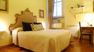 フィレンツェにあるAppartamento Vellutiniのベッドルーム(テーブル、デスク、ベッド付)