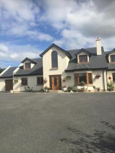 a large white house with a black roof at The Crossroads B&B in New Ross