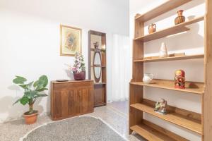 ein Wohnzimmer mit Holzregalen und Pflanzen in der Unterkunft Appartamento con AC-wi-fi- centro a 7 min in Savona