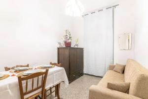 ein Wohnzimmer mit einem Tisch und einem Sofa in der Unterkunft Appartamento con AC-wi-fi- centro a 7 min in Savona
